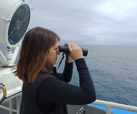 Cassie Layton with binoculars on the ship
