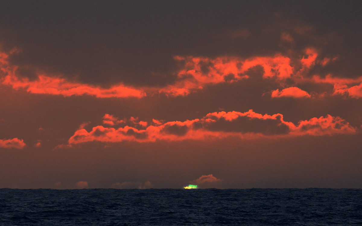 Green flash at sunset over water 